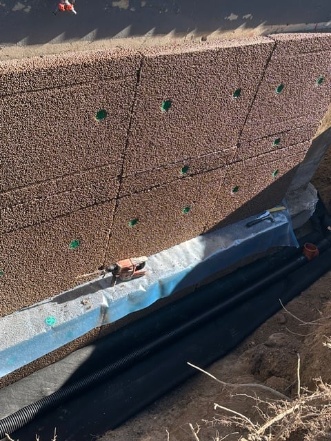 Aerial view of a cotton harvest with green crop-dusting equipment operating across rows of harvested cotton bolls